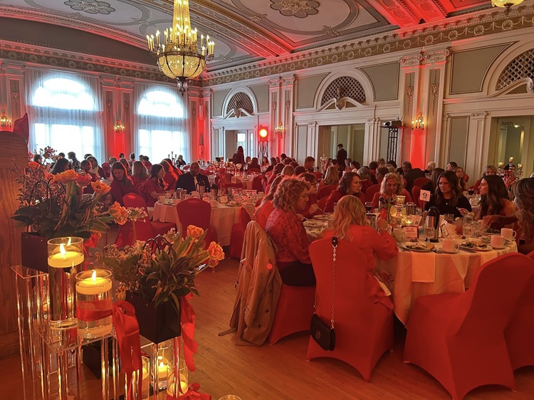 Image of the ballroom filled with guests dressed in red.